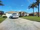 Charming single-story home with well-manicured lawn, mature trees, and a paved driveway leading to an attached garage at 517 Westwind Dr, Davenport, FL 33896