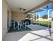 Relaxing screened patio features comfortable seating, a ceiling fan, and a view of the backyard at 517 Westwind Dr, Davenport, FL 33896