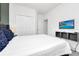 Bright bedroom with a large bed, closet space, and a mounted TV for entertainment at 518 Marcello Blvd, Kissimmee, FL 34746