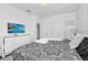Bright bedroom featuring a large bed, dresser, and TV with a tropical beach scene at 518 Marcello Blvd, Kissimmee, FL 34746