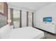 Bright bedroom featuring large windows, white furniture, and a wall-mounted TV at 518 Marcello Blvd, Kissimmee, FL 34746
