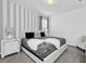 Modern bedroom featuring a striking black and white palette with patterned bedding and striped walls at 518 Marcello Blvd, Kissimmee, FL 34746
