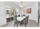 Elegant dining area with a modern white table, gray velvet chairs, and sliding glass door to pool at 518 Marcello Blvd, Kissimmee, FL 34746