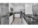 Bright kitchen features white cabinetry, stainless steel appliances, and a black granite countertop at 518 Marcello Blvd, Kissimmee, FL 34746