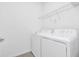 Clean, white laundry room featuring a washer and dryer with overhead shelving at 518 Marcello Blvd, Kissimmee, FL 34746