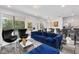 Open living area with a modern blue couch, sleek chairs, access to the pool, and a dining area at 518 Marcello Blvd, Kissimmee, FL 34746