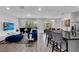 Open-concept living room with stylish decor, lots of seating, and sliding glass doors to patio at 518 Marcello Blvd, Kissimmee, FL 34746