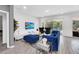 Beautiful living room featuring a plush blue couch, modern décor, and large sliding glass doors to pool at 518 Marcello Blvd, Kissimmee, FL 34746