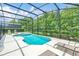 Sparkling pool and jacuzzi surrounded by a screened enclosure and lounge chairs at 518 Marcello Blvd, Kissimmee, FL 34746