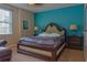 Cozy bedroom with blue accent wall, a king bed, lamps, and bedside tables at 531 Lasso Dr, Kissimmee, FL 34747