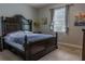 Comfortable bedroom with a dark wood bed frame, natural light, and neutral-colored walls at 531 Lasso Dr, Kissimmee, FL 34747