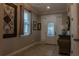 Welcoming foyer with neutral tile flooring, a front door with glass panels, and decorative wall art at 531 Lasso Dr, Kissimmee, FL 34747