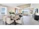 Open-concept dining area with modern furniture and bright lighting; kitchen in the background at 5512 Settlingstone Ln, St Cloud, FL 34771