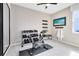 The home gym features an exercise bike, weight rack, bench, wall-mounted yoga mat holders and a flat screen TV at 5512 Settlingstone Ln, St Cloud, FL 34771