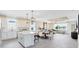 Open-concept kitchen and dining area with white cabinets, pendant lighting, and stainless steel appliances at 5512 Settlingstone Ln, St Cloud, FL 34771