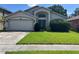 Charming single Gathering home featuring a well-manicured front lawn and a two-car garage at 581 Farmingham Ct, Oviedo, FL 32765