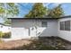 Exterior backyard featuring a white wall with a window, a door, and grassy area at 657 Lear Ter, Deltona, FL 32725