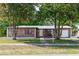 Charming brick home featuring mature trees, a manicured lawn, and an inviting front entrance at 657 Lear Ter, Deltona, FL 32725