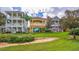 Backyard lawn with manicured landscaping and balconies overlooking the lawn at 7411 Excitement Dr, Reunion, FL 34747