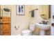 Compact bathroom featuring a pedestal sink, framed art, and woven storage baskets, perfect for guests at 7411 Excitement Dr, Reunion, FL 34747