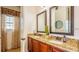 Bathroom with granite countertops, double sinks, and a decorative window with curtains at 7411 Excitement Dr, Reunion, FL 34747