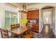 Cozy dining area with hardwood floors, a large wooden table, and a view of the kitchen at 7411 Excitement Dr, Reunion, FL 34747