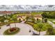 Exterior view of community with decorative circle driveway, palms, and beautiful landscaping at 7411 Excitement Dr, Reunion, FL 34747