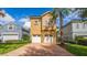 Inviting two-story home with a brick driveway, lush landscaping and attached two-car garage at 7411 Excitement Dr, Reunion, FL 34747