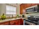 Kitchenette featuring stainless steel appliances, granite counter, and wood cabinets at 7411 Excitement Dr, Reunion, FL 34747