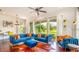 Stylish living room featuring hardwood floors, plush blue sofas, and an abundance of natural light at 7411 Excitement Dr, Reunion, FL 34747
