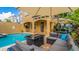 Backyard retreat with an outdoor kitchen, a sparkling pool, and comfortable seating perfect for relaxation and entertaining at 7411 Excitement Dr, Reunion, FL 34747