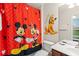 Themed bathroom featuring a Mickey Mouse shower curtain and playful decor at 7754 Teascone Blvd, Kissimmee, FL 34747