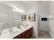 Bright bathroom with a double sink vanity, large mirror, and walk-in shower at 7754 Teascone Blvd, Kissimmee, FL 34747