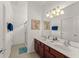 Bathroom featuring a double sink vanity, a large mirror and a glass-enclosed shower at 7754 Teascone Blvd, Kissimmee, FL 34747