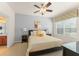 Bright bedroom with a ceiling fan, side tables, and a comfortable queen size bed with yellow accents at 7754 Teascone Blvd, Kissimmee, FL 34747