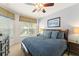 Relaxing bedroom with two windows, ceiling fan, and comfortable queen size bed with blue accents at 7754 Teascone Blvd, Kissimmee, FL 34747