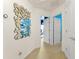 Hallway with unique geometric wall art, neutral colors, and white doors at 7754 Teascone Blvd, Kissimmee, FL 34747