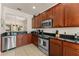 Modern kitchen featuring stainless steel appliances, granite countertops, and tile flooring at 7754 Teascone Blvd, Kissimmee, FL 34747