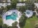 Aerial view of the community pool and hot tub area, showcasing mature landscaping and outdoor amenities at 7900 S Orange Blossom Trl # 1099, Orlando, FL 32809