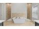 This bathroom features a white soaking tub and neutral colored tile in the shower at 7974 Chilton Dr, Orlando, FL 32836