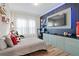 A sports themed bedroom featuring a modern design with a mounted TV and built-in storage at 7974 Chilton Dr, Orlando, FL 32836