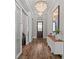 Elegant hallway with hardwood floors, chandelier lighting, console table, and decorative mirror at 7974 Chilton Dr, Orlando, FL 32836