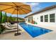 Beautiful pool area with outdoor kitchen, dining, lounge chairs, and mature landscaping at 7974 Chilton Dr, Orlando, FL 32836