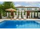 Beautiful pool surrounded by comfortable lounge chairs, landscaping and a large umbrella at 7974 Chilton Dr, Orlando, FL 32836
