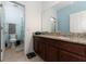 Well-lit bathroom featuring a granite vanity top, dark wood cabinets, and a separate toilet and shower area at 9348 Meadow Hunt Way, Winter Garden, FL 34787