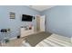 Comfortable bedroom with a TV, light blue walls, and white furniture at 9348 Meadow Hunt Way, Winter Garden, FL 34787