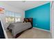 Bright bedroom featuring a bed, neutral carpet, natural light from the window and a colorful accent wall at 9348 Meadow Hunt Way, Winter Garden, FL 34787
