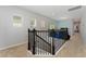 Upstairs hallway with carpet flooring, natural light, and a wrought iron banister at 9348 Meadow Hunt Way, Winter Garden, FL 34787