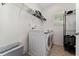 Bright laundry room featuring a modern washer and dryer, ample shelving, and natural light at 9348 Meadow Hunt Way, Winter Garden, FL 34787