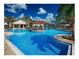 Resort style pool featuring palm trees, lounge seating, splash pad, and a covered area at 9348 Meadow Hunt Way, Winter Garden, FL 34787